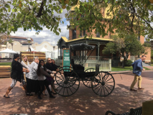 The Square PHX staff and volunteers, having fun with the carriage in front of Rosson House.