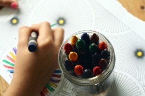 A picture of someone coloring with brightly colored crayons.