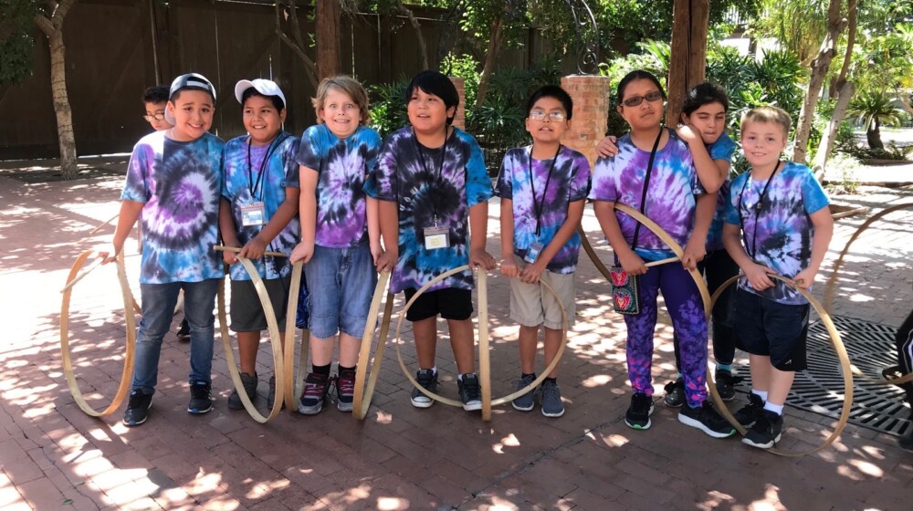 A picture of a group of students posing with 19th century lawn games.