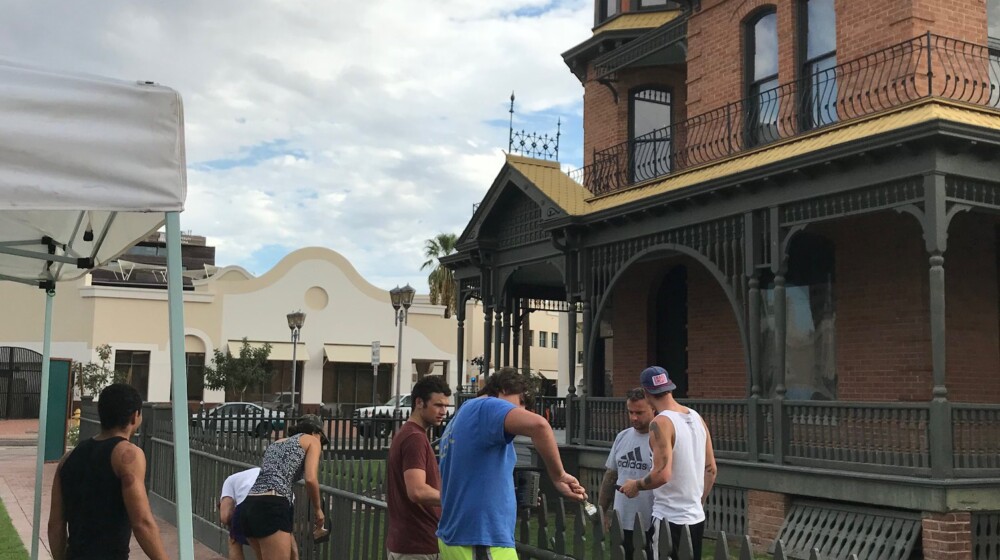 The Square PHX volunteers painting the Rosson House fence.