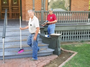 Two The Square PHX volunteers, cleaning and repairing the front steps of Rosson House.