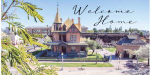 A picture of Rosson House Museum and the Visitor Center Carriage House with the Lath Pavilion and Monroe School in the background, and the words, “Welcome Home.”