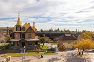 A picture of Rosson House Museum and the Visitor Center Carriage House during winter at The Square PHX, with the leaves on many of the trees turing yellow.