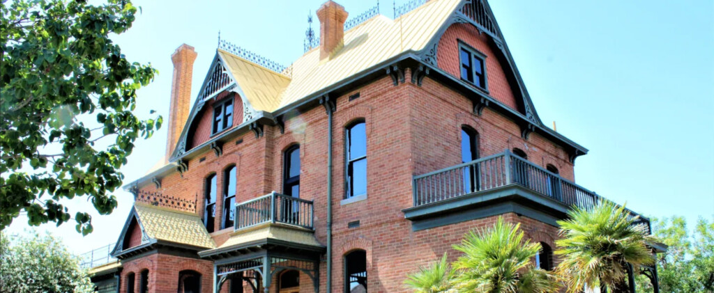 A view of the Rosson House, looking at the southeast corner of the home, with blue skies and green trees.