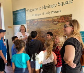 A picture of several students and their chaperone listening to a The Square PHX staff member as they start their field trip at The Square PHX.