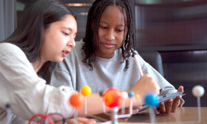 A picture of two students learning about the solar system.