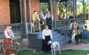 People dressed in Renaissance costume with greyhounds
