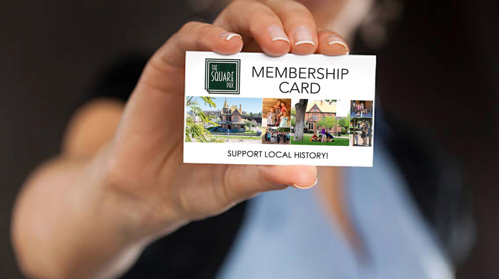 Photo of a person holding a membership card out in front of them, promoting museum memberships.